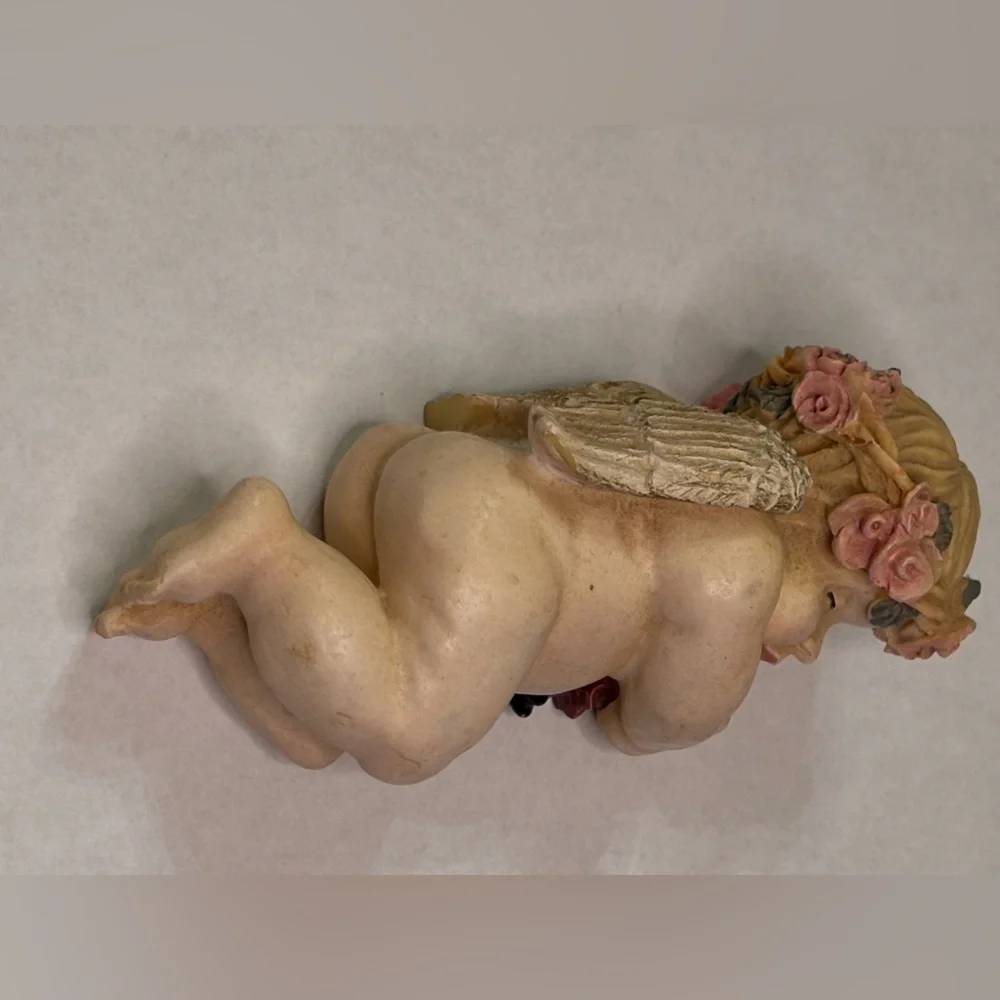 Sleeping Cherub Figurine holding a doll with Floral Crown
